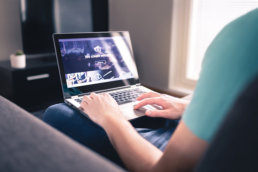 Person navigation a website with a laptop on their lap